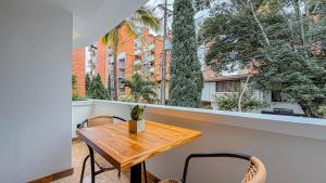 a wooden table and chairs on a balcony with a window at Primavera Lofts in Medellín
