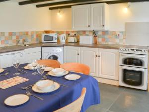 a kitchen with a table with a blue table cloth at Culvada in Treknow