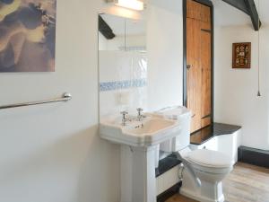 a bathroom with a white sink and a toilet at Culvada in Treknow +4 photos
