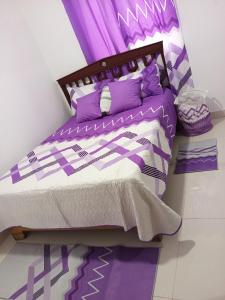 a bedroom with a purple bed with purple sheets and pillows at Colinas del Sol Res perfect in Jacagua +7 photos