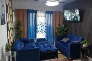 a living room with blue couches and blue curtains at Colinas del Sol Res perfect in Jacagua