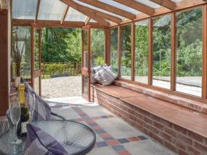 a screened in porch with a table and chairs at Woodpecker Rest in Cilgerran