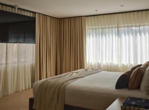 a bedroom with a bed and a large window at The Ivory in Los Angeles