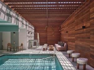 a swimming pool with a table and chairs next to it at The Ivory in Los Angeles