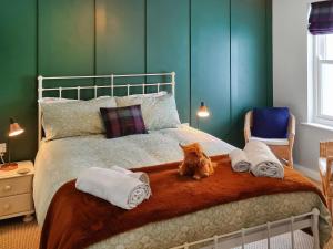 an orange cat sitting on a bed with towels at 10 Elm Court in Keswick