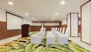 a conference room with white chairs and a podium at Mosaic Hotel Mussoorie Mallroad in Mussoorie