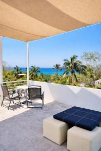a patio with a table and chairs and the ocean at Cocos House Zicatela in Puerto Escondido