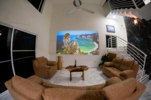 a living room with couches and a painting on the wall at Cocos House Zicatela in Puerto Escondido