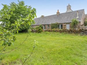 an old house with a grass yard in front of it at The Cottage in Bankfoot