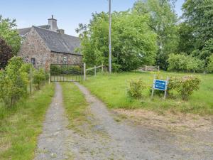 a dirt road in front of a stone house at The Cottage in Bankfoot +8 photos