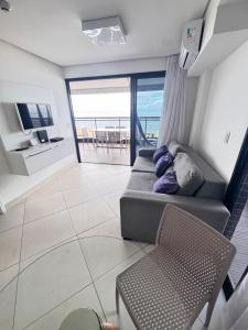 a living room with a couch and a television at Hotel Platinum - Landscape Luxo - in Fortaleza