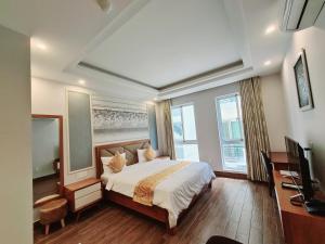 a bedroom with a bed and a flat screen tv at GreenStay Hotel & Apartment in Ho Chi Minh City +24 photos