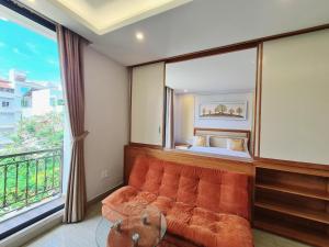a room with a couch and a bed and a window at GreenStay Hotel & Apartment in Ho Chi Minh City