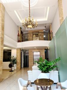 a lobby with a chandelier and a table and chairs at GreenStay Hotel & Apartment in Ho Chi Minh City