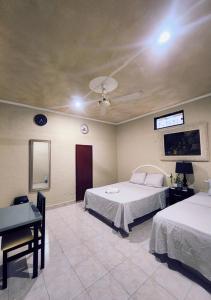 a bedroom with two beds and a table and a ceiling at Posada Azeneth in Oxkutzcab +25 photos