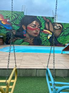 two swings in a playground with a painting on the wall at Espaço festa Angini in Manaus