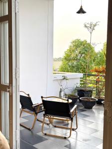 two chairs sitting on the porch of a house at Chu homestay in Thôn Trường Giang