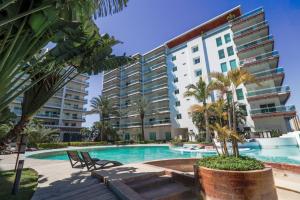a swimming pool in front of a large building at Pacifika in Mazatlán