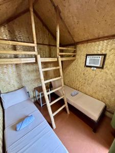 a room with two bunk beds and a ladder at Nipa Hut Lodging House in Coron +8 photos