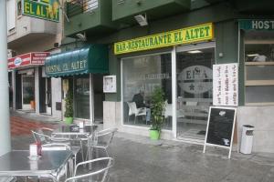 a restaurant with tables and chairs in front of a store at Hostal El Altet in El Alted