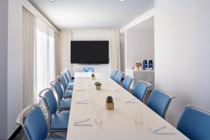 ein Konferenzraum mit einem langen Tisch und blauen Stühlen in der Unterkunft The Valorian Los Angeles, Curio Collection by Hilton in Los Angeles + 118 Fotos
