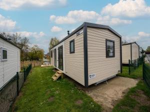 a white tiny house sitting in a yard at Berlare Retreat for 6 with garden in Berlare