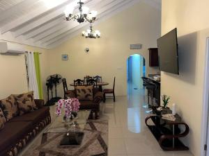 a living room with a couch and a table at Serenity Vacation Villa in Ocho Rios