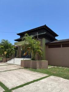 a house with palm trees in front of it at Serenity Vacation Villa in Ocho Rios