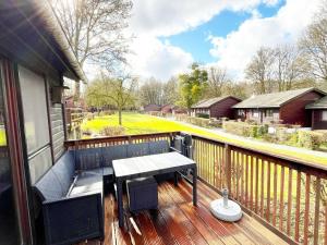 a balcony with a wooden deck with a table and chairs at Cozy chalet for 6 people in Rendeux