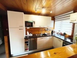 a kitchen with a white refrigerator and a sink at Cozy chalet for 6 people in Rendeux