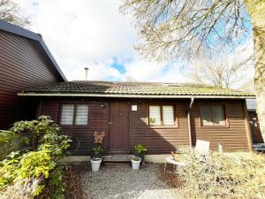 a small wooden house with plants in front of it at Cozy chalet for 6 people in Rendeux