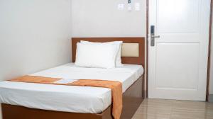a small bedroom with a bed with a wooden headboard at Emmie Hotel in Legazpi