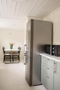 a kitchen with a stainless steel refrigerator and a table at Cozy apartment in Sola +11 photos