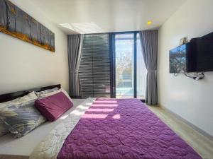 a bedroom with a bed with a purple blanket at Villas 930 Oceanami in Long Hai +18 photos