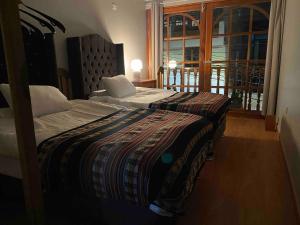 a bedroom with two beds and a large window at Attic Hotel in Chachapoyas