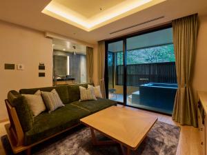 a living room with a green couch and a table at Hakone Suishoen in Hakone