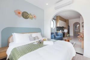 a bedroom with a white bed and a blue couch at Artsy Boutique Studio in Hanoi