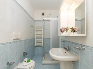 a bathroom with a sink and a toilet and a mirror at Mobilehome am Luganersee in Porlezza +30 photos