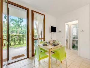 a dining room with a table and green chairs at Mobilehome am Luganersee in Porlezza