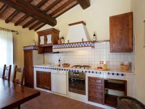 a kitchen with a stove top oven next to a table at Pretty farmhouse with terrace in Radda in Chianti