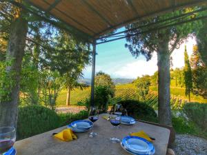 a table with plates and wine glasses on top of it at Pretty farmhouse with terrace in Radda in Chianti