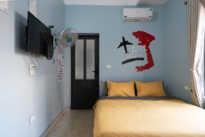 a bedroom with a bed and a flat screen tv at Lola's House in Ha Long