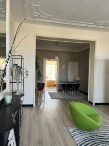 a living room with a green chair and a table at Westersingel 24-2 in Rotterdam