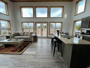 a kitchen and living room with a couch and a table at Spruce Arch - King Bed Fireplace Pets Welcome in Rogers
