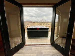 an open door to a tub on a deck at Spruce Arch - King Bed Fireplace Pets Welcome in Rogers