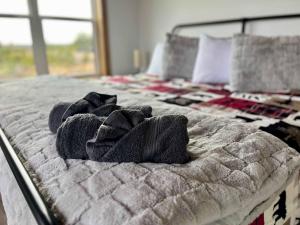 a bed with a pile of towels on it at Spruce Arch - King Bed Fireplace Pets Welcome in Rogers