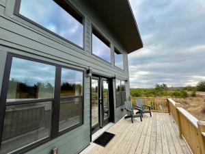 a house with a deck with a bench on it at Spruce Arch - King Bed Fireplace Pets Welcome in Rogers +14 photos