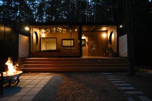 a small house with a fire in front of it at Fuji Fumoto Forest Onsen ふじ ふもとの森温泉 in Fujikawaguchiko