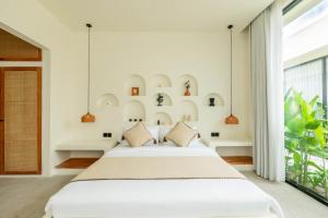 a bedroom with a bed and a large window at Soma House - Adults Only in Kuta Lombok