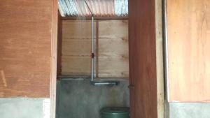 a bathroom with a toilet in a wooden wall at Adefiro Homestay in Besir